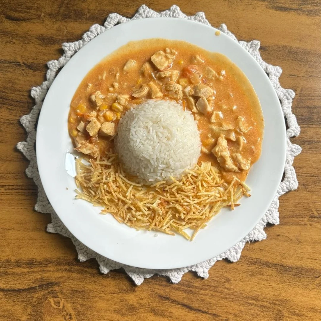 Estrogonofe de frango real servido com arroz e batata palha